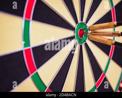 Eine Nahaufnahme von drei Darts im Bullseye von Eine Dartscheibe Stockfoto