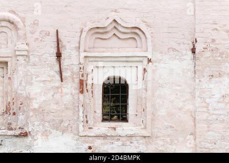 Kleines Fenster in einer alten weißen Steinmauer. Hintergrundfotostruktur Stockfoto