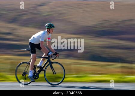 Junge Radfahrer, die gegen den Wind auf den Yorkshire Moors Mit Bewegungsunschärfe im Hintergrund Stockfoto