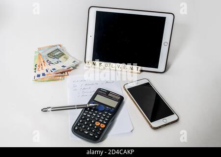 Bamberg, Deutschland. Oktober 2020. Bamberg, Deutschland 7. Oktober 2020: Symbolische Bilder - 2020 - auf weißem Hintergrund sind Bargeld, Euro-Scheine, ein Tablet, eine handschriftliche Notiz, ein Rechner, ein Handy und der insolventen Schriftzug zu sehen. Quelle: dpa/Alamy Live News Stockfoto