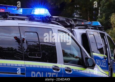 Dresden, Deutschland. Okt. 2020. Zwei Polizeifahrzeuge mit blinkenden blauen Lichtern stehen diagonal versetzt an einem Einsatzort. Quelle: Tino Plunert/dpa-Zentralbild/ZB/dpa/Alamy Live News Stockfoto