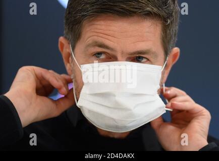 Dresden, Deutschland. Oktober 2020. Fußball: 3. Liga, Pressekonferenz zum 4. Spieltag vor dem SG Dynamo Dresden - 1. FC Magdeburg Spiel in der transparenten VW Manufaktur. Dynamos Sportdirektor Ralf Becker setzt nach der Pressekonferenz seinen Mundschutz an. SG Dynamo Dresdens Heimspiel in der 3. Liga gegen den 1. FC Magdeburg an diesem Samstag (10.10.2020) wird voraussichtlich mit deutlich reduzierter Zuschauerzahl stattfinden müssen. Quelle: Robert Michael/dpa-Zentralbild/dpa/Alamy Live News Stockfoto