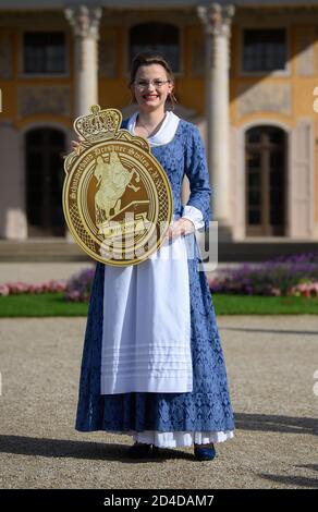 Dresden, Deutschland. Okt. 2020. Johanna Meitzner, das 26. Dresdner Stollenmädchen, hält das Gütesiegel bei ihrer Präsentation im Schlosspark Pillnitz in den Händen. Der 21-jährige Bäckerlehrling ist für ein Jahr Botschafter des Dresdner Christstollens im Auftrag der Dresdner Stollenbäcker. Quelle: Robert Michael/dpa-Zentralbild/ZB/dpa/Alamy Live News Stockfoto