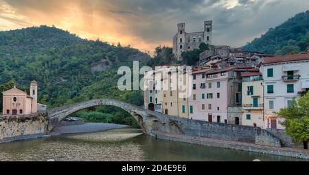 DOLCEACQUA, ITALIEN - CA. AUGUST 2020: Dolceacqua Panorama mit der antiken römischen Brücke aus Steinen und der Burg Stockfoto