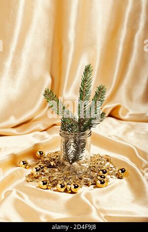 Tannenzweig und Weihnachtskugeln auf goldenem Hintergrund. Neues Jahr feiern Konzept Stockfoto