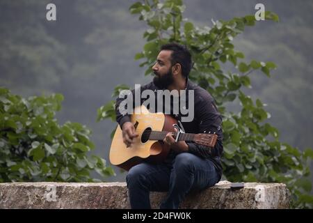 Dehradun, Uttarakhand/Indien-September 12 2020:EIN junger Gitarrist in wunderschönen Hügeln. Stockfoto