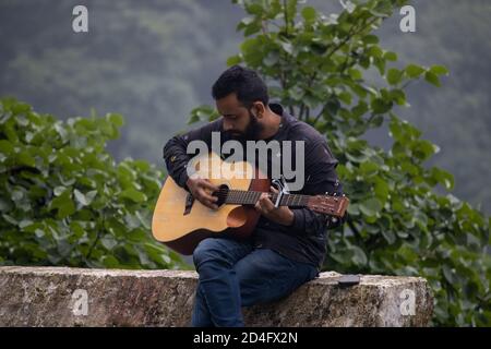 Dehradun, Uttarakhand/Indien-September 12 2020:EIN junger Gitarrist in wunderschönen Hügeln. Stockfoto