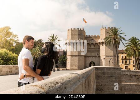 Glückliches junges Paar zu Besuch in Valencia, Torres de Serranos Tor im Hintergrund Stockfoto