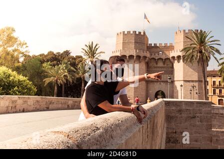 Glückliches junges Paar zu Besuch in Valencia, Torres de Serranos Tor im Hintergrund Stockfoto