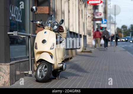 Riga, Lettland - 8. Oktober 2020: Ein klassischer, eleganter Vespa-Roller, der auf einem Fußgängerweg in der Innenstadt geparkt ist Stockfoto