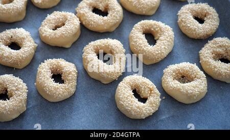 Nahaufnahme Sesamsamen, die auf den Teig geklebt sind, winzige Bagels mit Sesamsamen, Stockfoto