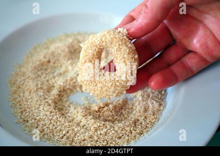 Nahaufnahme Sesamsamen, die auf den Teig geklebt sind, winzige Bagels mit Sesamsamen, Stockfoto