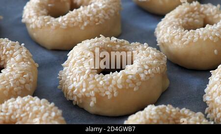 Nahaufnahme Sesamsamen, die auf den Teig geklebt sind, winzige Bagels mit Sesamsamen, Stockfoto