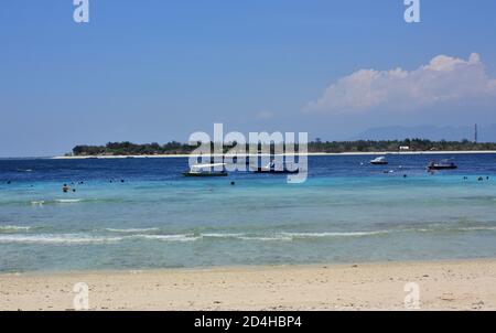 Blick nach Osten über klares blaues Wasser in Richtung Gili Meno, Foto am Strand von Gili Trawangan, Indonesien Stockfoto
