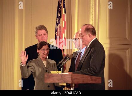 Präsident Bill Clinton sieht sich an als Oberrichter William Rehnquist den Eid of Office an Richterin Ruth Bader Ginsburg als Associate Supreme Court Justice im Weißen Haus verwaltet, 10. August 1993. Foto von Ralph Alswang / Fotograf des Weißen Hauses / Aktenzeichen # 1003-833THA Stockfoto