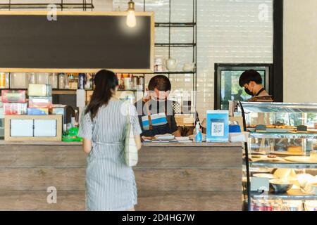 Social Distance Conceptual Small Business Kellner, die Kunden im Café bedienen. Stockfoto