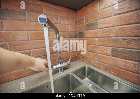 Wasser läuft aus Metall Wasserhahn in der Küche. Schließen des Taps Stockfoto
