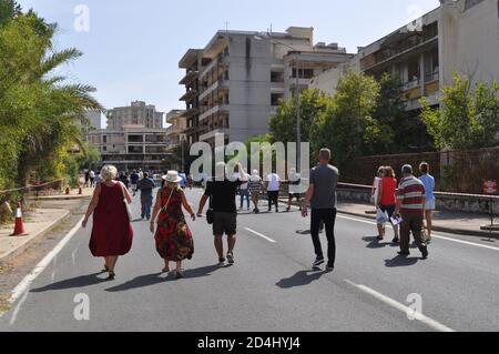 Famagusta, Nordzypern. Okt. 2020. Dieses Bild vom 8. Oktober 2020 zeigt Menschen, die den verlassenen Badeort Varosha in der türkischen Republik Nordzypern (TRNC) zum ersten Mal seit 46 Jahren betreten. Die türkisch-zypriotische Regierung hat Anfang dieser Woche beschlossen, dieses eingezäunte Gebiet von Famagusta teilweise wieder zu öffnen. Varosha blieb jahrzehntelang unberührt und wurde nach dem Zypernkrieg 1974 von den türkischen Behörden abgedichtet, als seine überwiegend griechisch-zypriotischen Einwohner flohen und die Insel geteilt wurde. (Fotos von Selim KUMBARACI / Pasedembo / Alamy Live News Stockfoto