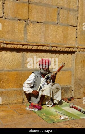 Ein Mann mit Turban sitzt auf dem Boden und spielt Vilolin bei Jaiselmer Rajasthan Indien am 21. Februar 2018 Stockfoto