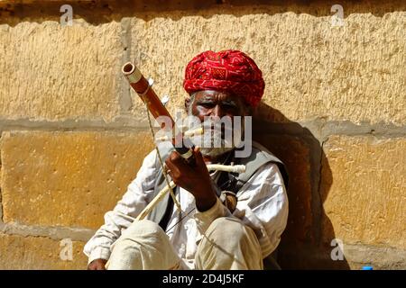 Ein Mann mit Turban sitzt auf dem Boden und spielt Vilolin bei Jaiselmer Rajasthan Indien am 21. Februar 2018 Stockfoto