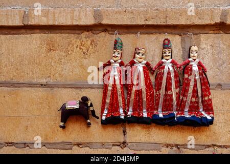 Bunte menschliche geformte Puppen tragen bunte Kleidung hängen gegen die Mauer in Rajasthan Indien am 21. Februar 2018 Stockfoto