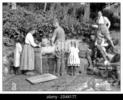 Propagandafoto des 1. Weltkriegs amerikanische Soldaten waschen ihre Kleidung mit Hilfe von französischen Dorfbewohnern in Lucy France 16-Aug-1918. Erster Weltkrieg Frankreich Stockfoto