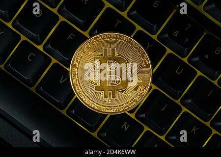 Bitcoin auf Computer Tastatur im Hintergrund, Symbol der elektronischen virtuelles Geld und Bergbau cryptocurrency Konzept. Münze crypto Währung bitcoin liegt auf Stockfoto