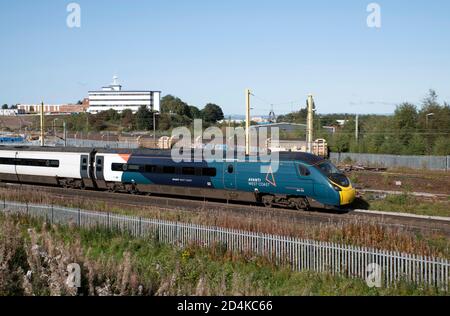 British Rail Klasse 390 Pendolino in Avanti West Coast Lackierung fährt Carlisle, Milton Hilltop Hotel im Hintergrund. Stockfoto