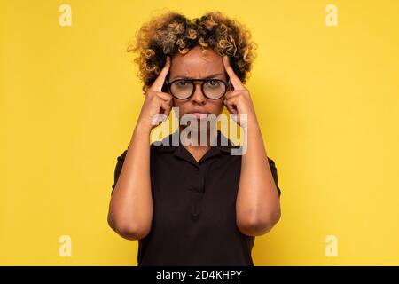 afroamerikanische Frau erzeugt neue Idee im Verstand, schaut nachdenklich Stockfoto