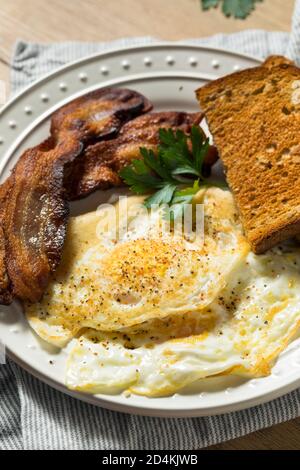 Hausgemachte über einfache Eier mit Speck und Toast Stockfoto
