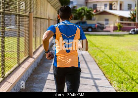 Rückansicht eines jungen Mannes, der draußen joggt Stockfoto