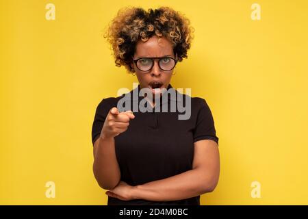 Es ist Ihre Schuld. Enttäuscht wütend junge afrikanische Frau runzelte mit Zeigefinger auf Kamera, Stockfoto