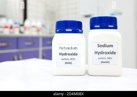 Selektiver Fokus einer Flasche aus reinem Natriumhydroxid und Kaliumhydroxid chemischer Verbindung. Chemie Forschungslabor Hintergrund mit Kopierraum. Stockfoto