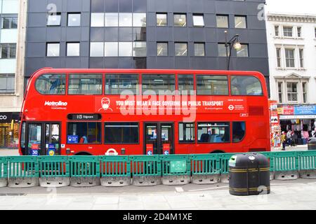 Tragen SIE EINE Gesichtsmaske auf der Seite eines Doppeldeckerbusses, Oxford Street, Central London Stockfoto