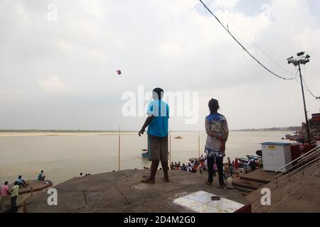 Kinder fliegen einen Drachen am Ganges Fluss in Varanasi, Indien Stockfoto