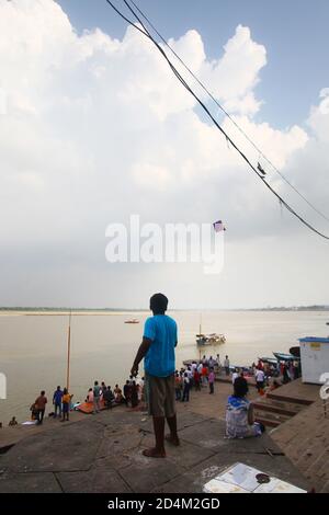 Kinder fliegen einen Drachen am Ganges Fluss in Varanasi, Indien Stockfoto