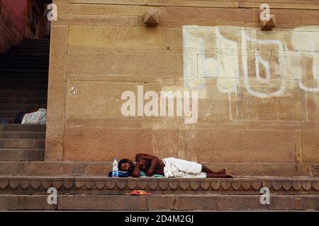 Ein Mann schläft am Ganges-Fluss in Varanasi, Indien. Stockfoto