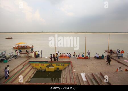 Menschen, die in der Nähe von Ganga Varanasi Stadt sitzen Stockfoto