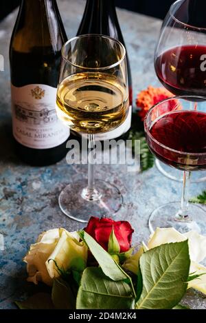 Rot-und Weißwein auf vintage blauen Hintergrund mit natürlichen Blumen Stockfoto
