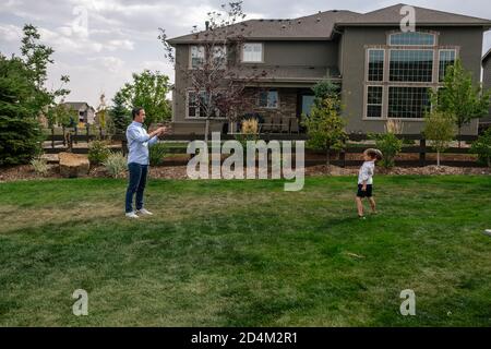 Vater und Sohn spielen Fang im Hinterhof Stockfoto