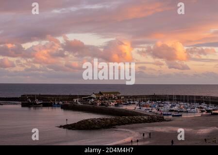 Lyme Regis, Dorset, Großbritannien. Oktober 2020. UK Wetter: Der Himmel über dem Cobb und Hafen leuchtet mit Sonnenuntergang Farbe bei Lyme Regis. Kredit: Celia McMahon/Alamy Live Nachrichten Stockfoto