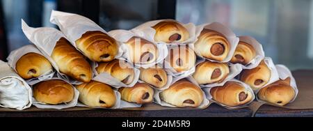 Frisch gebackene leckere Wurstbrötchen in einer Reihe, Fast Food, zum Mitnehmen Stockfoto