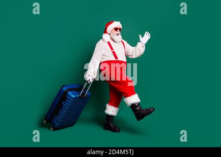 Volle Länge Körpergröße Profil Seitenansicht der schönen bärtigen Funky fröhlich übergewichtig Fett Santa Großvater trägt valise Flug Fliegen Sie ab Stockfoto