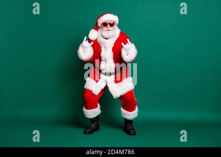 Volle Länge Körpergröße Ansicht seiner er schön attraktiv Gut aussehend bärtig fröhlich cool Santa Vater mit Spaß tanzen zeigen Doppelhornsymbol isoliert Stockfoto