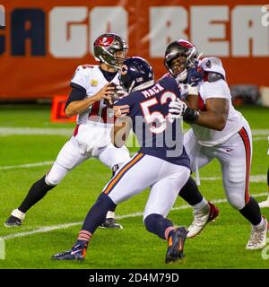 Chicago, Illinois, USA. Okt. 2020. - Buccaneers Quarterback #12 Tom Brady wirft den Ball vor eine Ladung Bären #52 Khalil Mack während des NFL-Spiel zwischen den Tampa Bay Buccaneers und Chicago Bären auf Soldier Field in Chicago, IL. Fotograf: Mike Wulf. Kredit: csm/Alamy Live Nachrichten Stockfoto