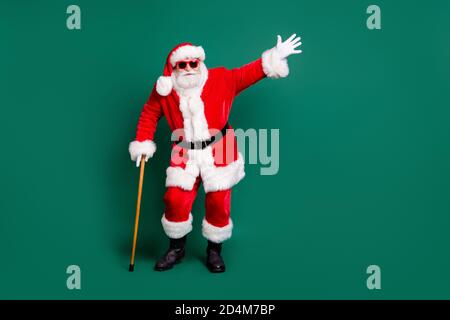 Volle Länge Körpergröße Ansicht seiner er schön attraktiv Fröhlich kindisch verspielt funky Santa lehnt auf Stock Spaß haben Feier Festal Tag Eve Noel Stockfoto