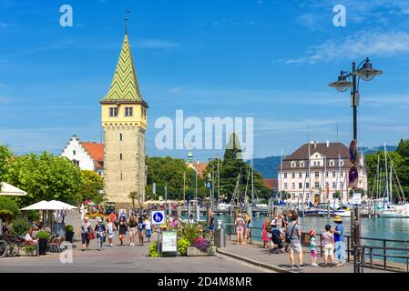 Lindau, Deutschland - 19. Juli 2019: Panorama des Lindauer Damms mit Mangturm am Bodensee oder Bodensee, im Sommer wandern die Menschen am Hafen entlang Stockfoto