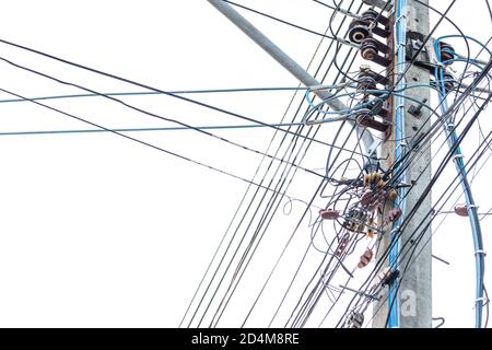 Die Drähte verwickelten sich an der elektrischen Säule. Unordentliche elektrische Kabel und Drähte am elektrischen Pol. Stockfoto