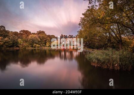 Eine lange Herbstexposition spiegelte sich über einem Teich in Hampstead Heath, London, England. Stockfoto