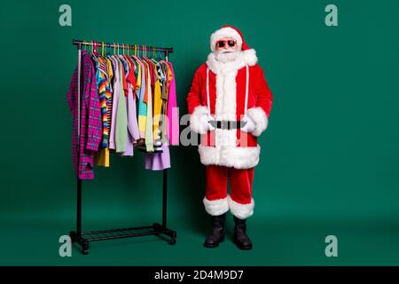 In voller Länge Foto von im Ruhestand stilvolle shopaholic Opa weißen Bart Geben Sie Geld teuer outwear tragen roten weihnachtsmann Kostüm Mantel Handschuhe Sonnenschutz Stockfoto